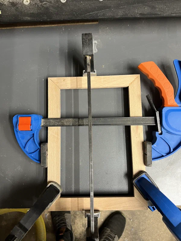 Wood frame held up with clamps, being glued up