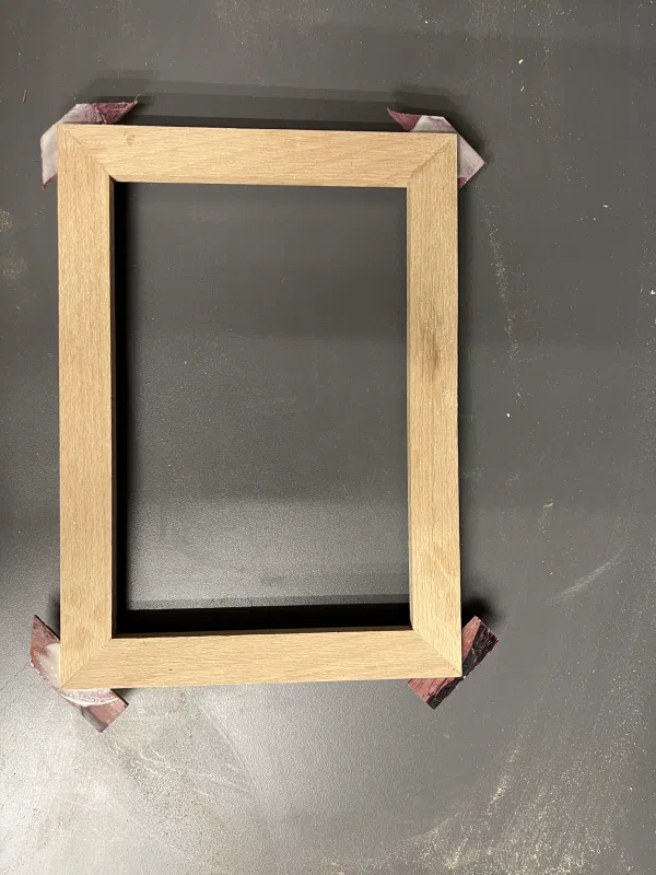 An oak picture frame top view, with each corner having a small spline glued in